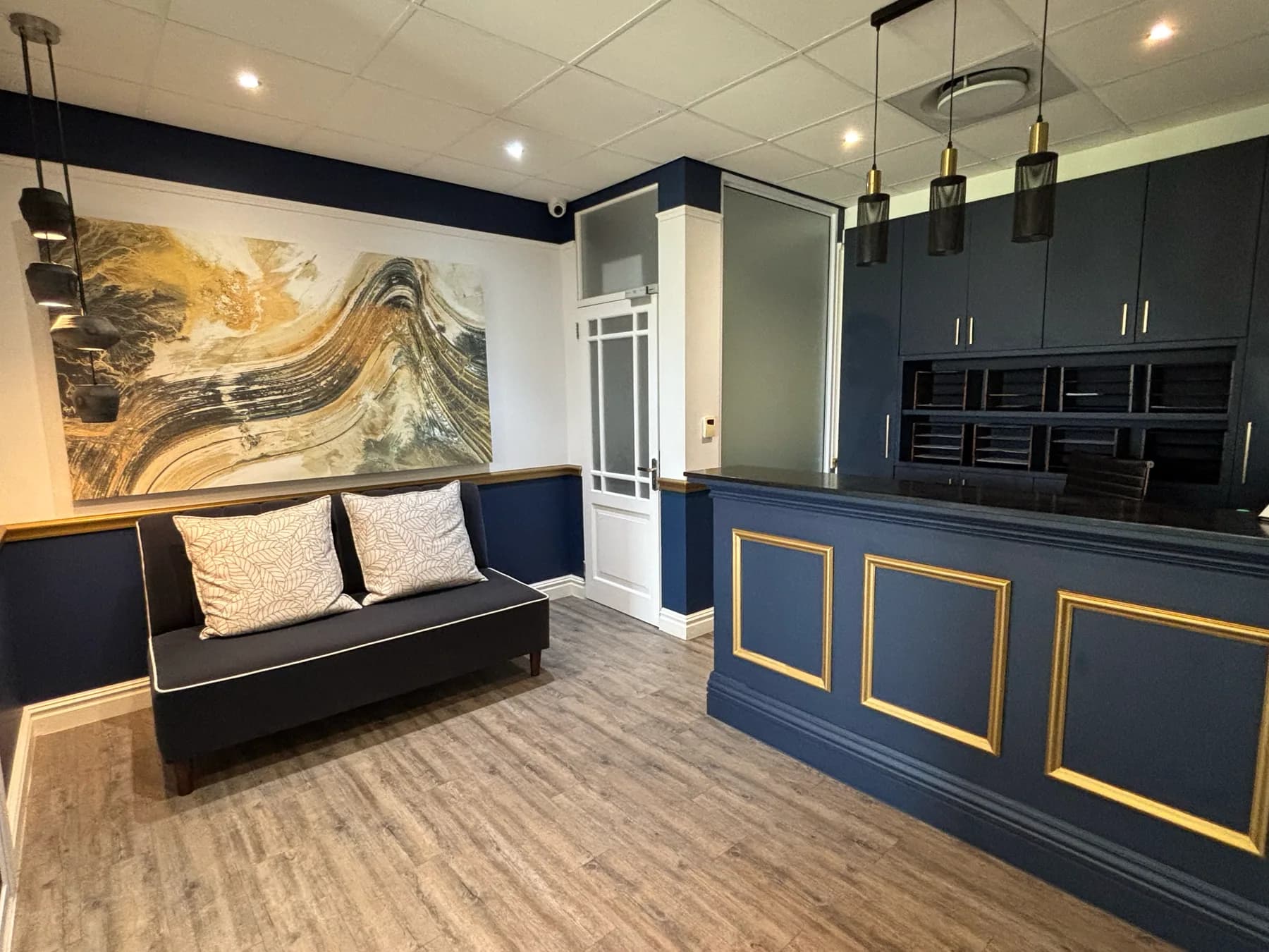The waiting area at Val de Vie: navy panelling, a bench and a reception desk.